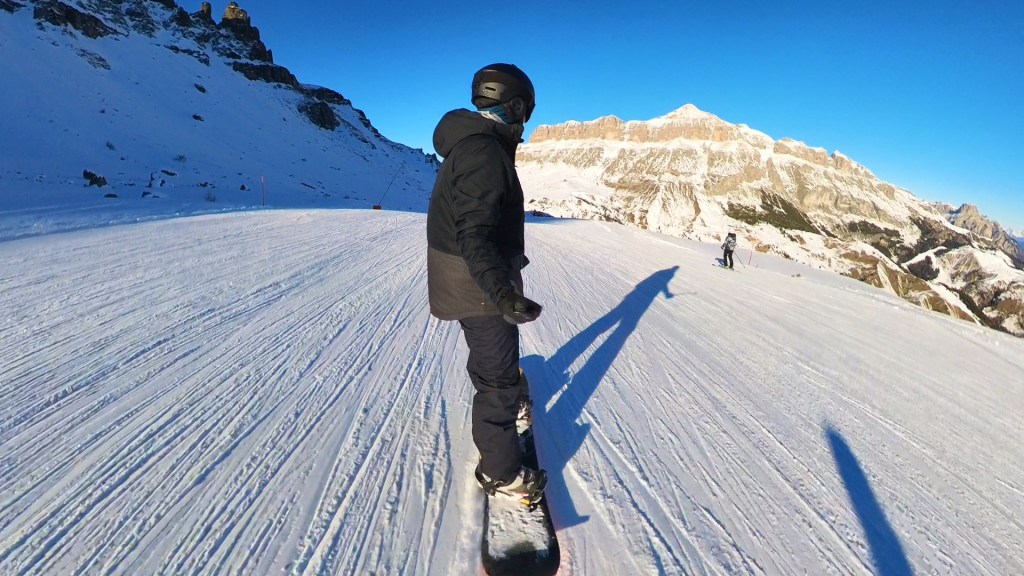 Snowboarding down a slope at the Sella ROnda with views of the mountains